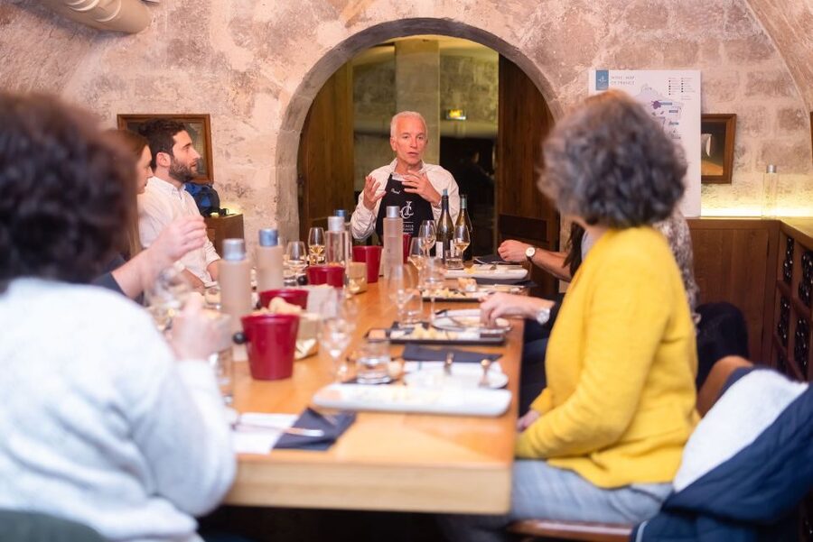 Paris: The Ultimate Wine and Cheese Tasting in English - Entering Les Caves du Louvre’s cellar vibe